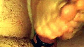 Busty wife with piercings gives an amateur footjob and masturbates