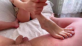 Amateur babe gives a footjob to a big cock in homemade video