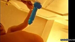 Alexis, a young girl, plays with a blue toy and squirts on a door