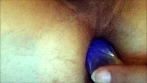 Young woman pleasures herself with a large anal toy, providing a close-up view