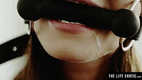 A brunette MILF experiences pleasure while pleasuring herself and gagged