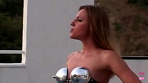 A blonde BDSM submissive in latex and heels receives dual penetration