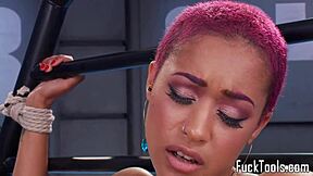 African-American woman with pink hair pleasures herself with a sex toy
