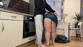 Son-in-law ejaculates on stepmother's voluptuous buttocks in the kitchen