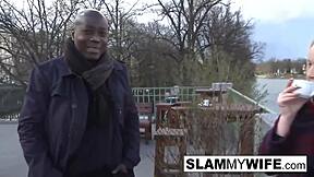 A blonde woman gets a big black cock in her ass while her husband watches