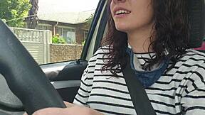 A skinny brunette masturbates outside by a car