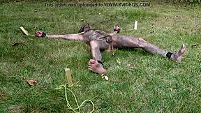Nuisette007 is tied up, naked, and suspended in the air in a spread eagle position outdoors
