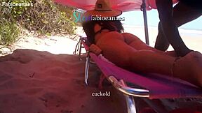 A black massage therapist gives a hand job to a married woman on her back at the beach