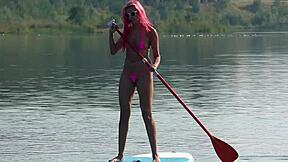 Tiny bikini clad beauty shows off her slim body outside