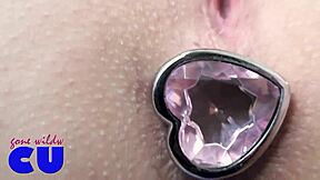 The girl is demonstrating her outfit with a butt plug