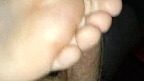 Amateur couple shares a steamy homemade footjob. Big cumshot covers her bare feet.