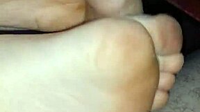 Amateur couple shares a steamy homemade footjob. Big cumshot covers her bare feet.